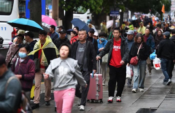4月24日,在贵阳市南明区花果园,游客正准备乘车前往省内各旅游景区。2 图片
