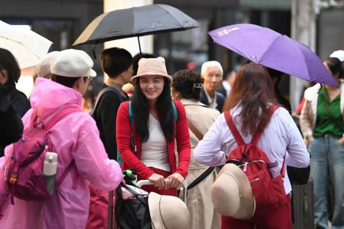 4月24日,在贵阳市南明区花果园,游客正准备乘车前往省内各旅游景区。 图片