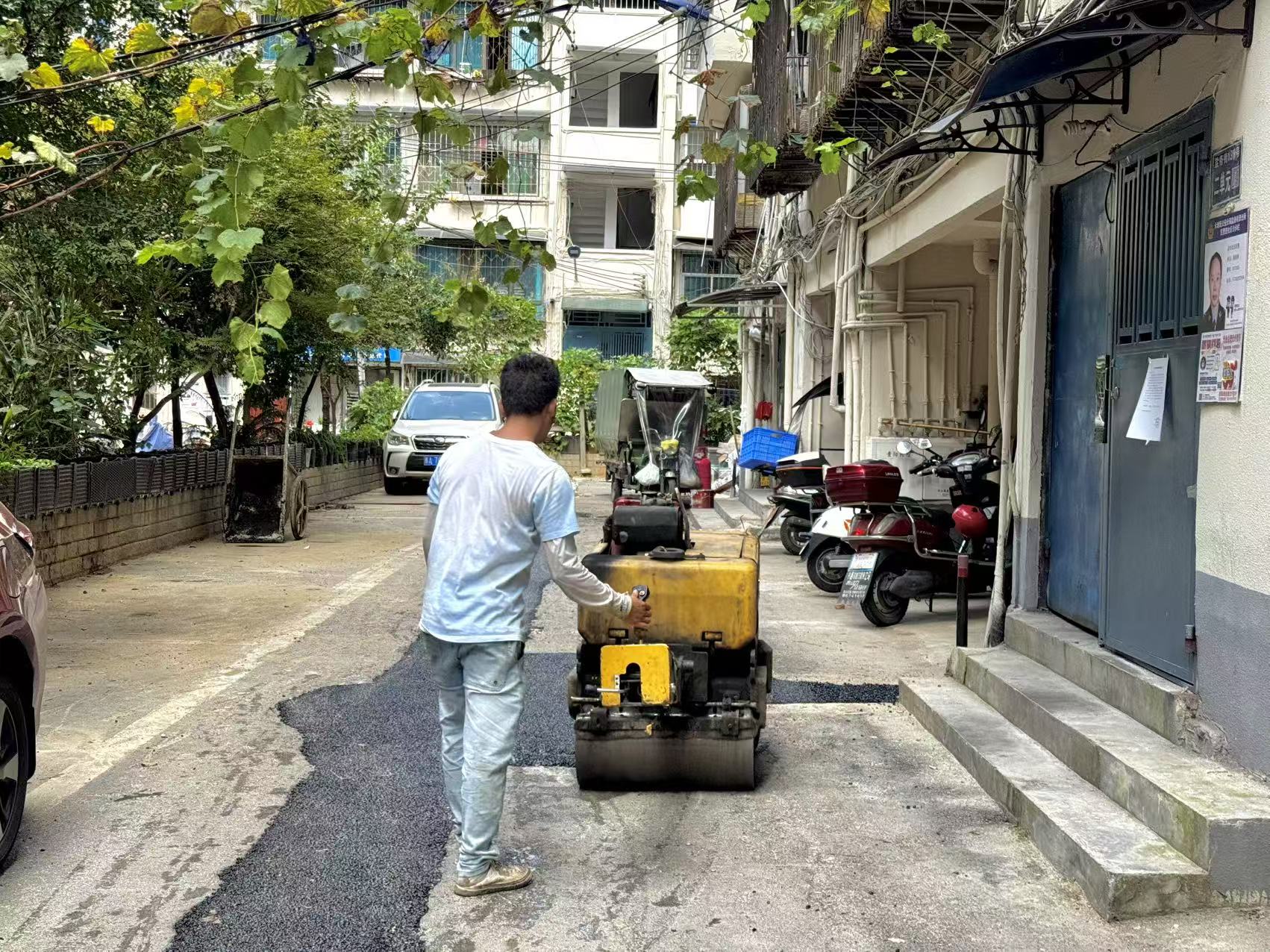 工人正对已完工路段铺设沥青