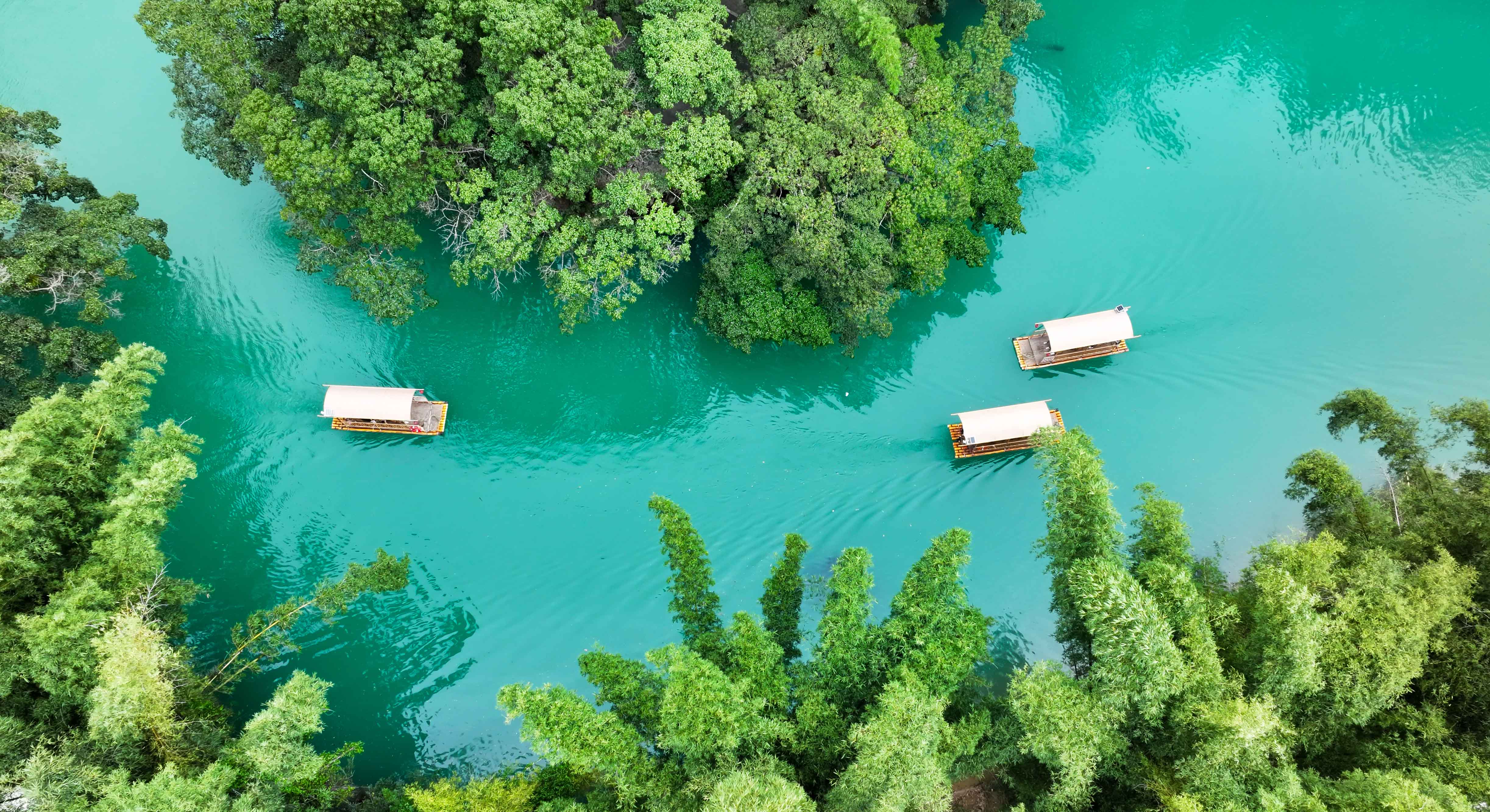 游客在大小井省级风景名胜区乘坐竹筏游览