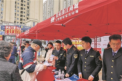 工作人员向群众发放消费维权相关宣传资料。