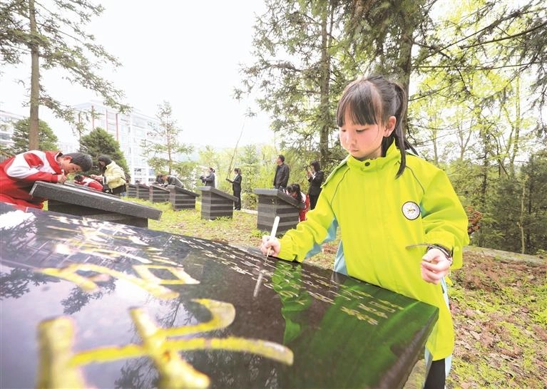 4月2日，毕节市在烈士陵园组织开展清明祭英烈活动，图为孩子们在为无名烈士墓擦拭除尘后认真描金，向革命先烈表达敬意。 黄忠贵 摄（影像贵州）.jpg