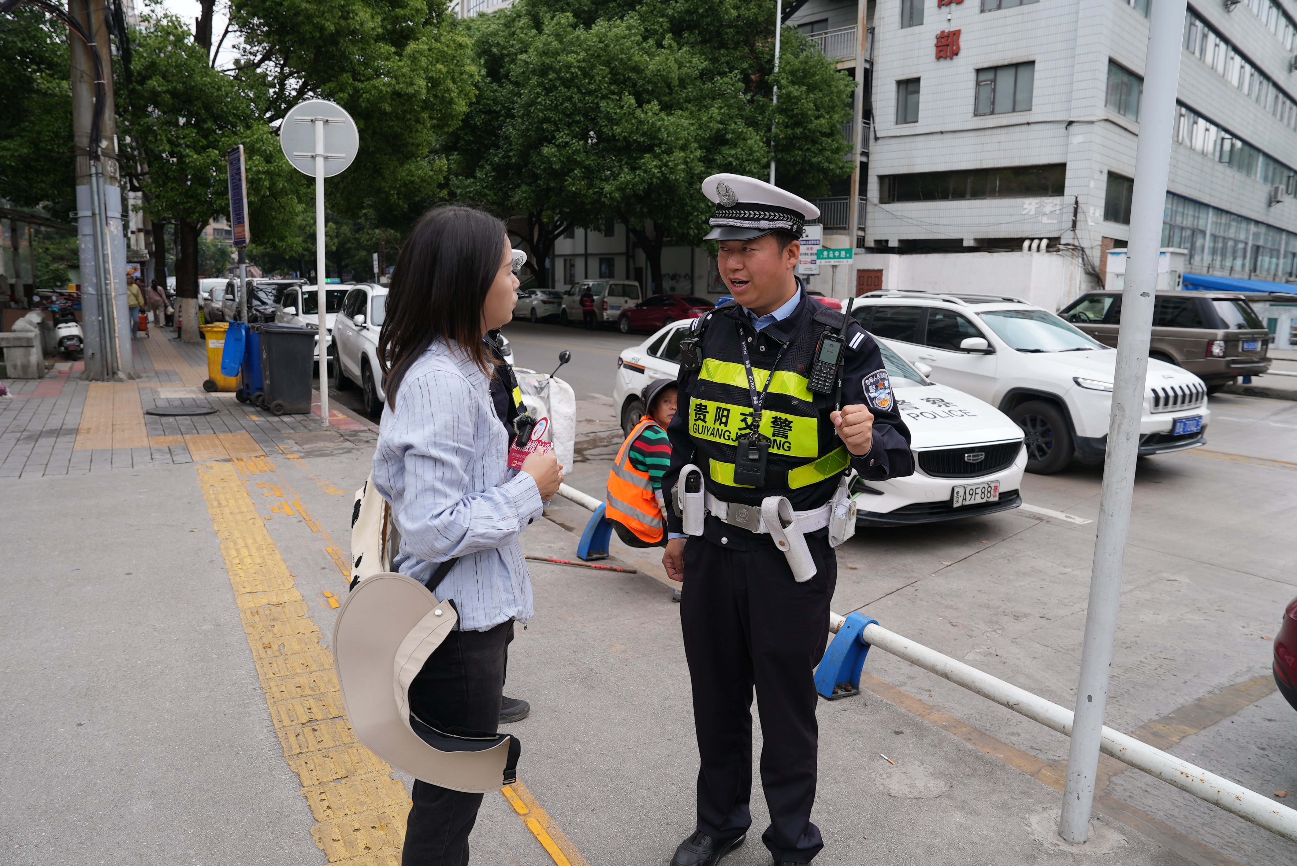 贵阳市公安局交通管理支队云岩大队四中队民警吴波(右)向工作组介绍情况
