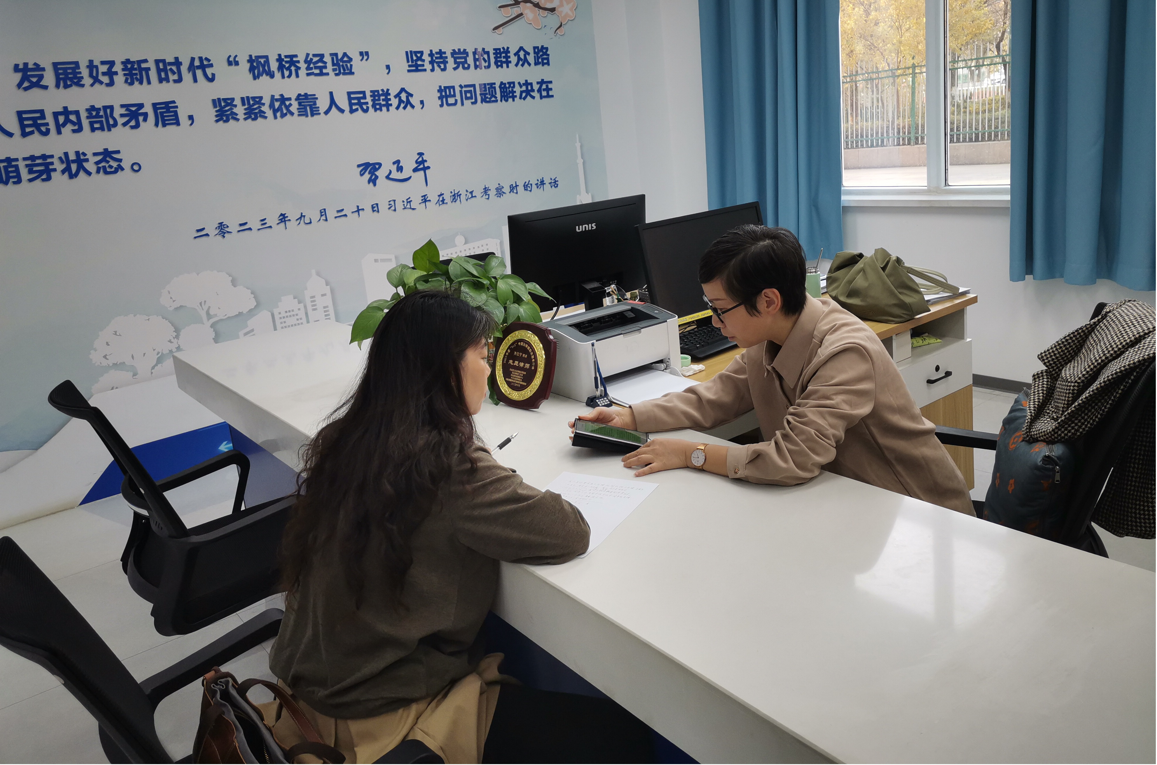 服务于新疆维吾尔自治区吐鲁番市托克逊县的“1+1”中国法律援助志愿者律师齐江宁(右)。
