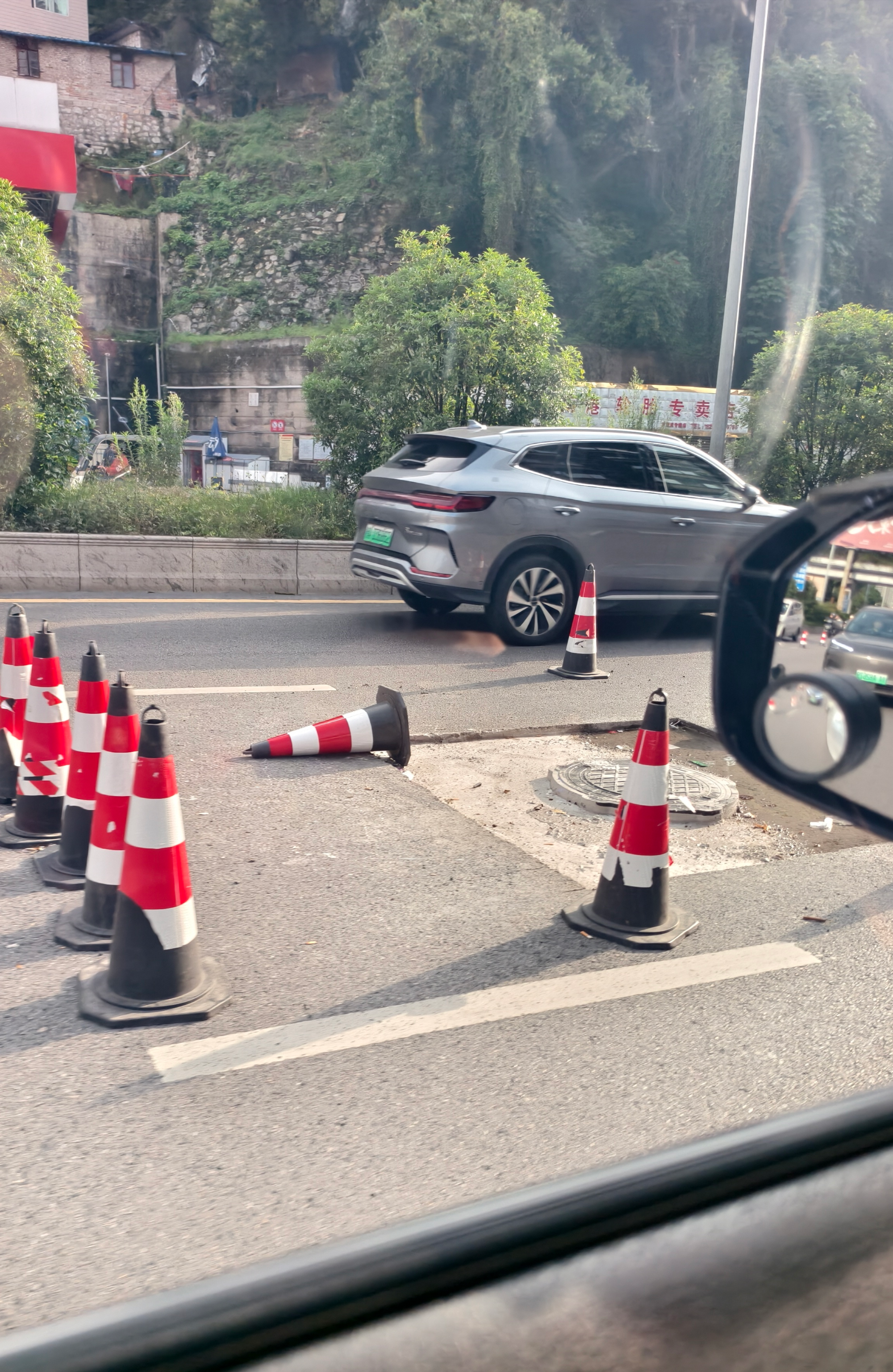 云岩区三桥北路公交站至转弯塘公交站路段，有井盖修补点位占用道路中间车道（市民供图）