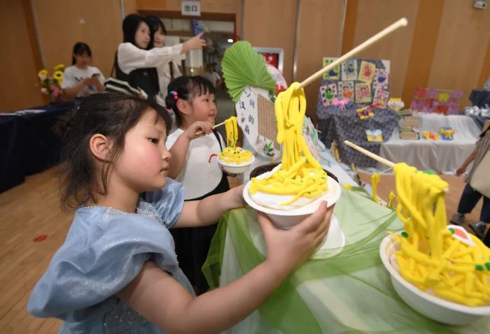 6月5日,贵阳市南明区苗苗幼儿园的小朋友正在劳动教育实践技能展演活动现场展示用粘土制作的面点美食。2 图片