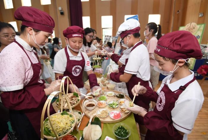 6月5日,贵阳市南明区花果园第三小学的学生正在劳动教育实践技能展演活动现场制作贵阳特色美食“丝娃娃”。2 图片