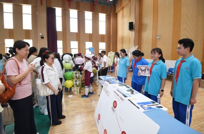 6月5日,贵阳市第十六中学的学生正在劳动教育实践技能展演活动现场宣传贵阳市红色经典一日游路线。 图片