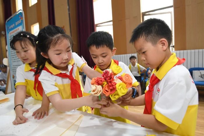 6月5日,贵阳市南明区甲秀小学的学生正在劳动教育实践技能展演活动现场制作爱心花束。 图片