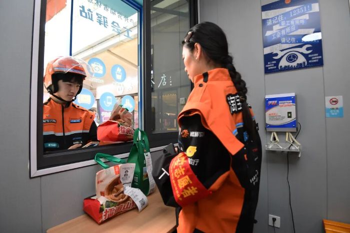 6月10日,在贵阳市南明区花果园购物中心集取点,干线骑手正在核对外卖信息。 图片