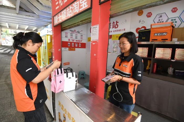 6月10日,在贵阳市南明区兰花都街道兰花社区淘宝闪购骑士驿站,送达端“步兵”派送员正取货,通过扫码开始订单派送。 图片