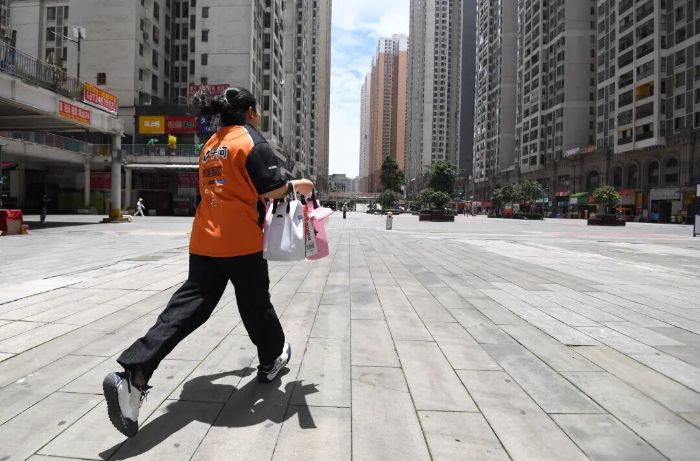 6月10日,送达端“步兵”派送员正在贵阳市南明区花果园大街派送外卖。 图片
